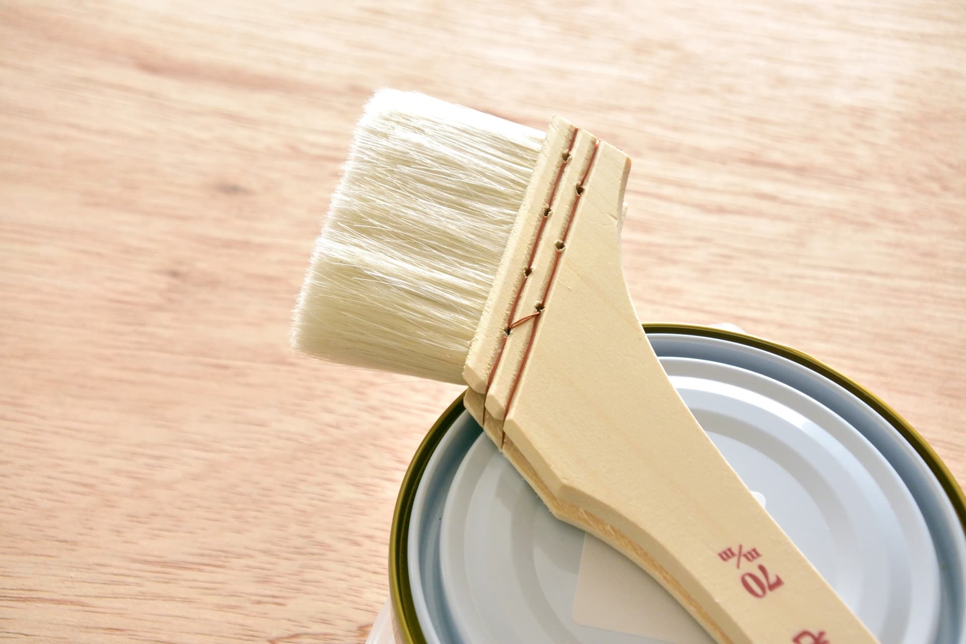 塗料缶の上に置かれた刷毛と塗装作業に使用する道具