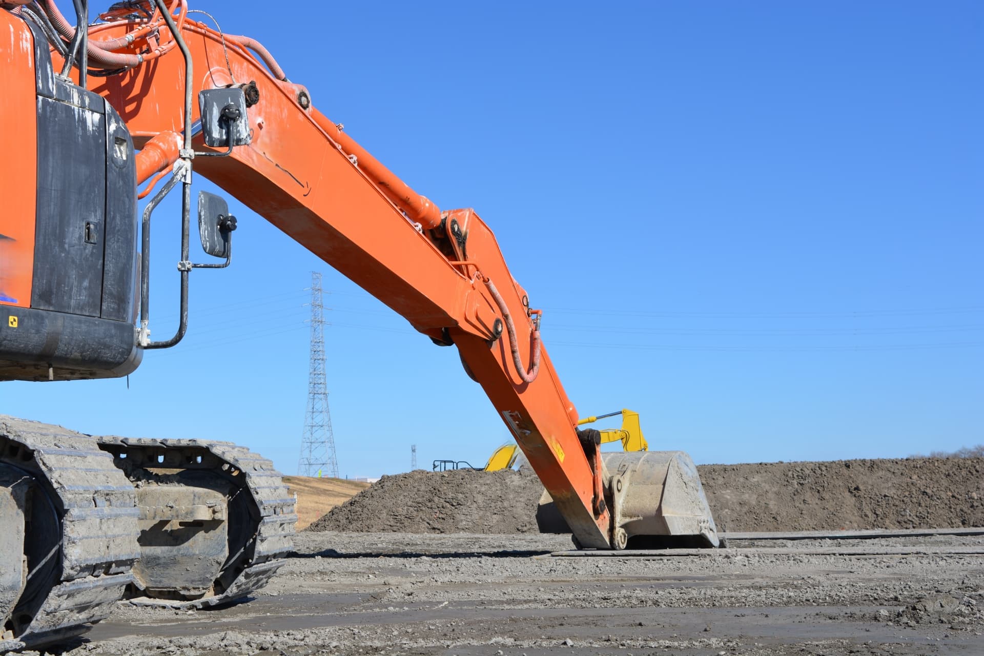 土木工事現場で稼働するバックホウによる地盤整備作業
