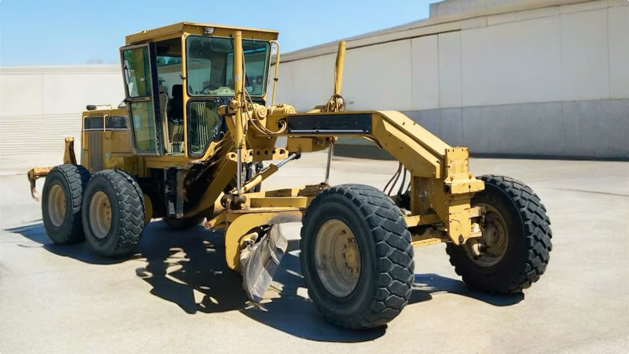 グレーダーがブレードで路面を整形する様子