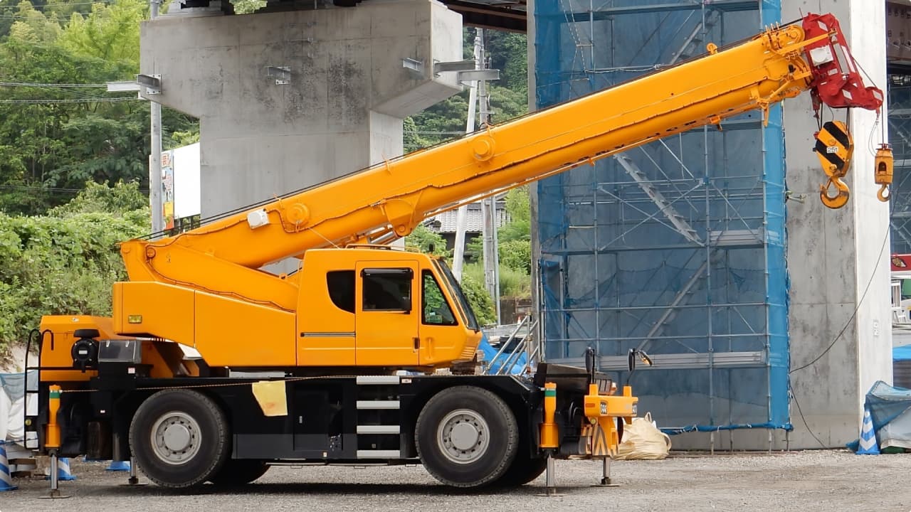 クレーン車が建設資材をつり上げて運搬する様子